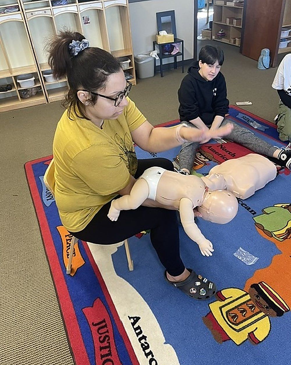 Practicing infant back blows during a childcare staff class